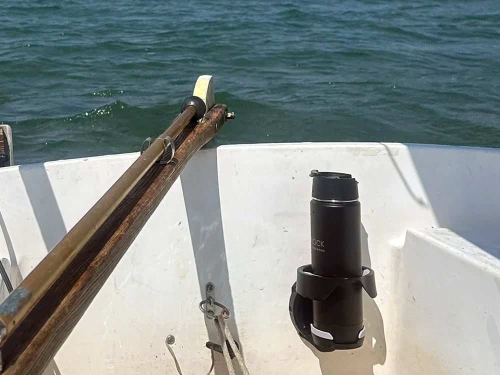 A TwistLock Vertical Mount Locking Cup Holder attached to a sailboat with a canteen locked in.