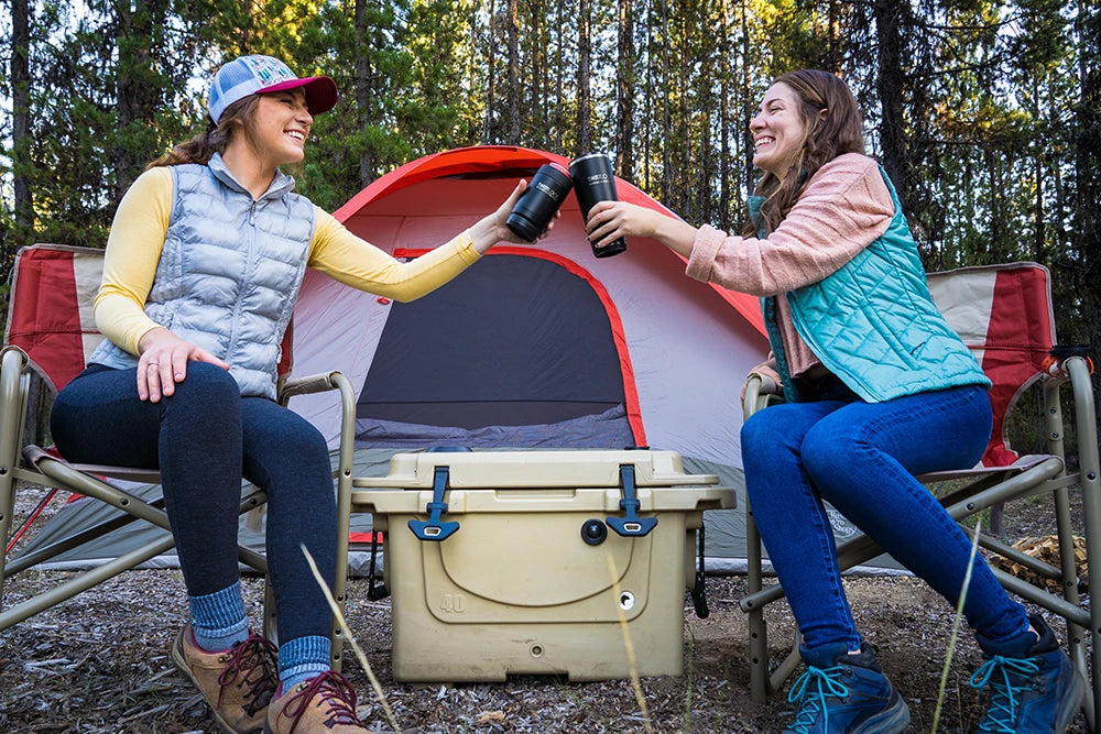 Camping in Oregon with Canteen and Can Cooler being toasted by two people.