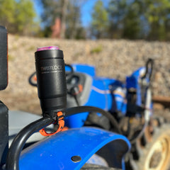 Bar mount locking cup holder attached to a tractor grab handle with a can cooler attached to it.