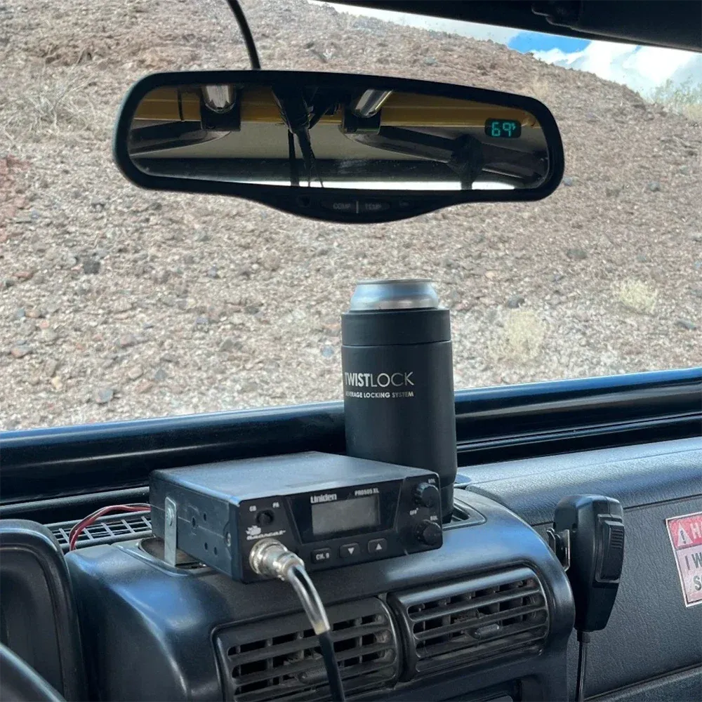 Dash of a truck with a secure cup holder and insulated can cooler.