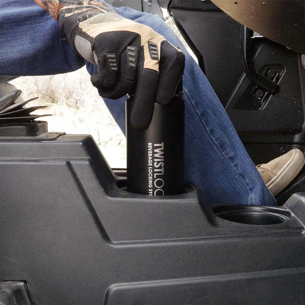 The driver locking in his insulated beverage into his cup holder before getting onto rough roads.