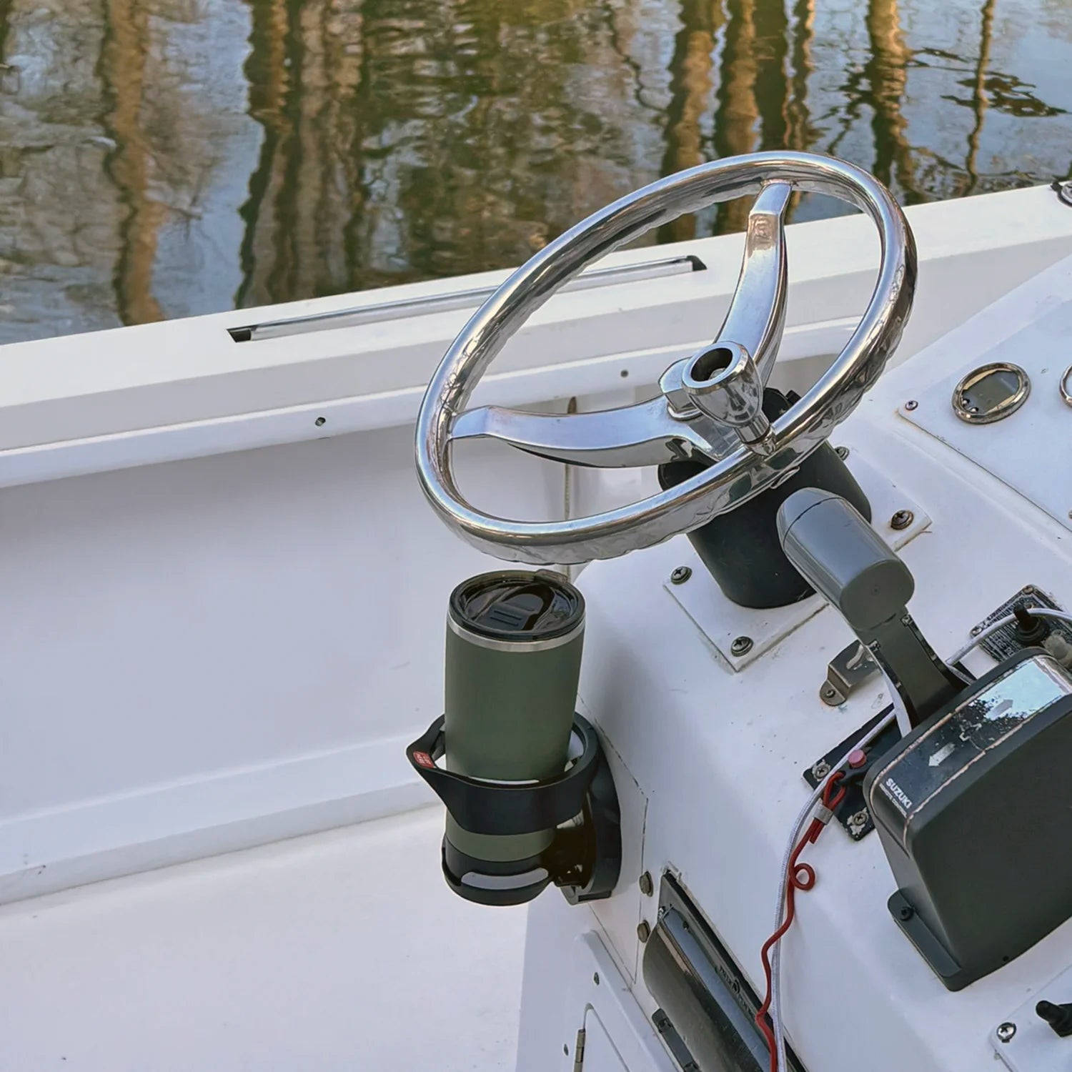 The TwistLock Folding Vertically Mounted Locking Cup Holder and 22oz Insulated Trailhead Green Tumbler on a Center Console Boat.