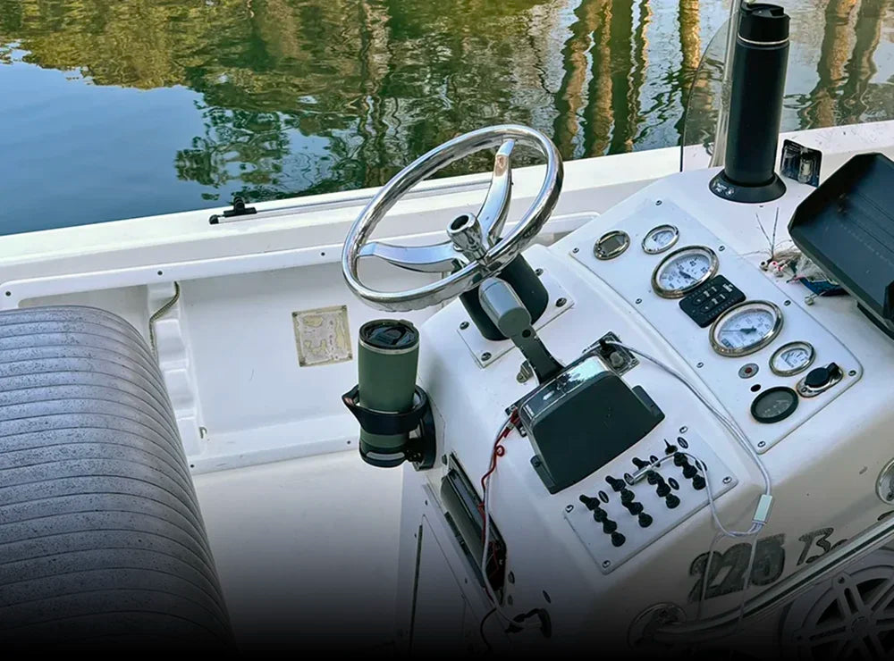 The TwistLock folding vertically mounted locking cup holder attached to a center console of a boat with a 22oz trailhead green tumbler locked into it.