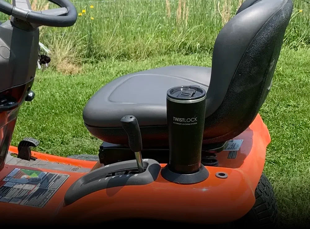 TwistLock Flat Mount secure locking cup holder attached to the side of a driving lawn mower.