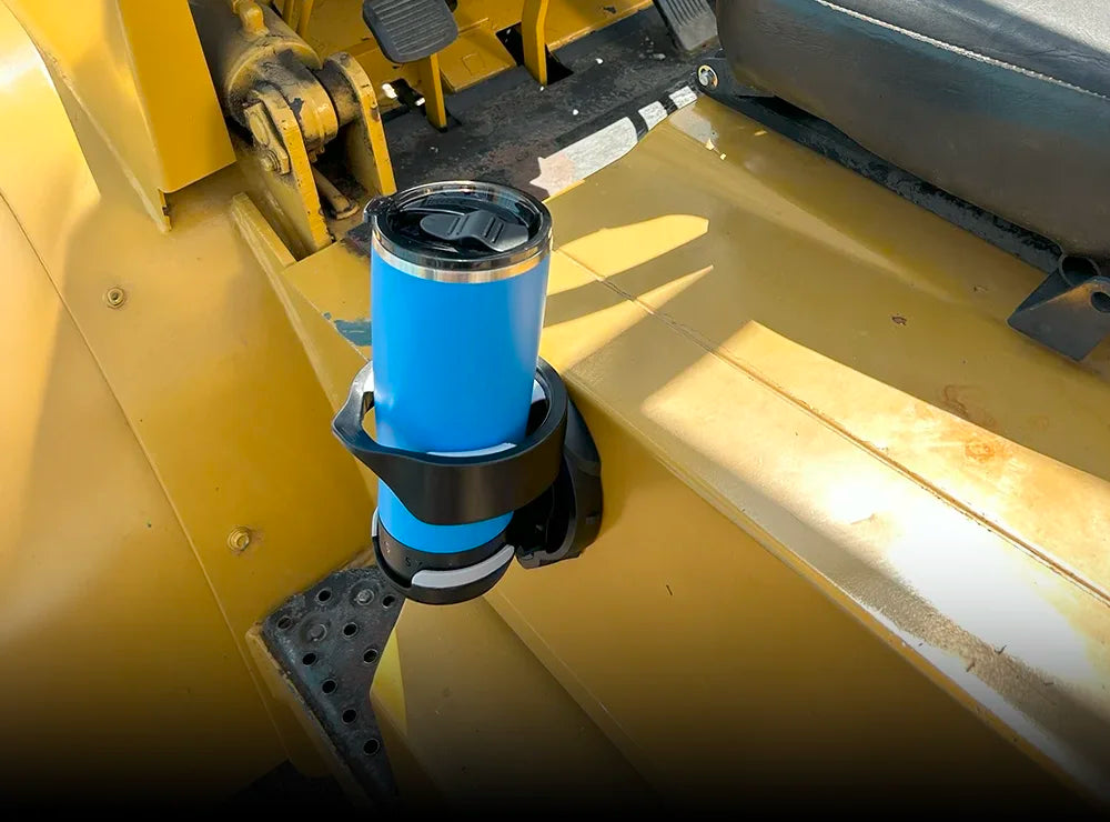 The TwistLock folding vertically mounted locking cup holder attached to a forklift with a 22oz insulated crater lake blue tumbler locked into it.