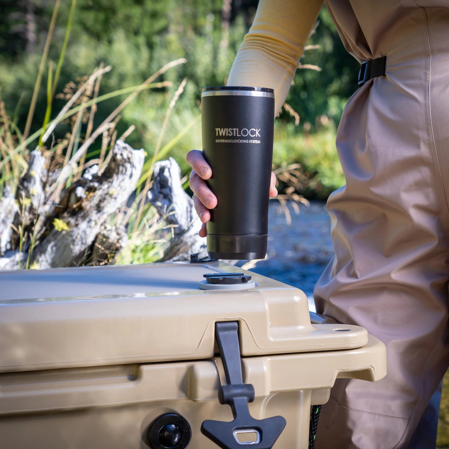 Fly fisher attaching their Insulated Tumbler into the attachable mini disc cup holder on their cooler.