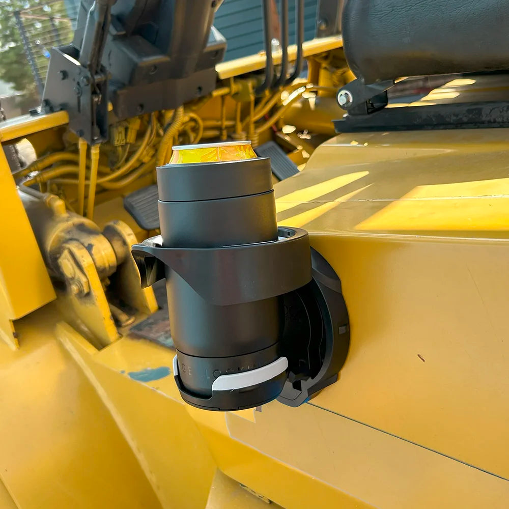 The TwistLock Vertical Mount Locking Cup Holder attached to the side of a forklift with an insulated black can cooler locked into it.