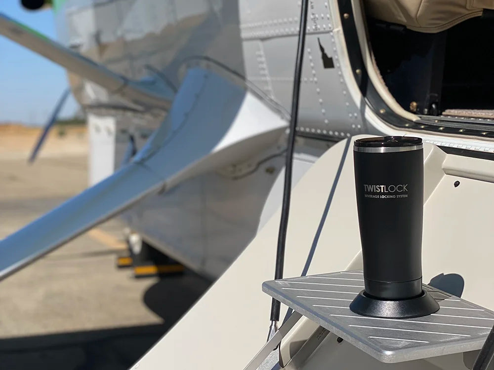 A TwistLock Tumbler and flat mount locking cup holder attached to a step on an airplane.