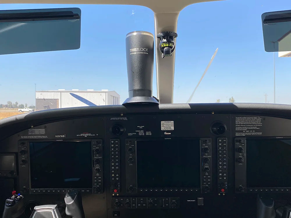 A TwistLock Tumbler and flat mount locking cup holder attached dash of an airplane.