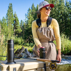 Fisher locking in her soda on a cooler lid with an insulated can cooler.