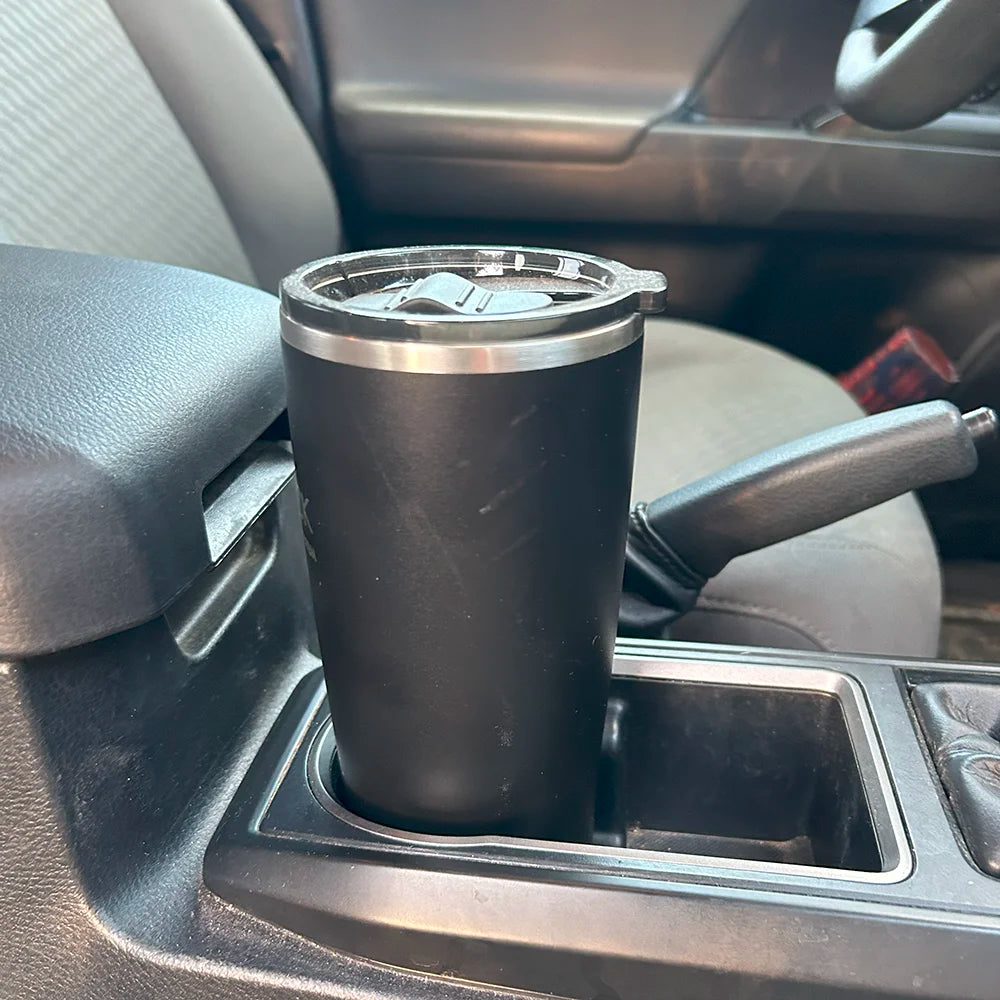 Insulated tumbler in a car cup holder with a spill proof locking base.