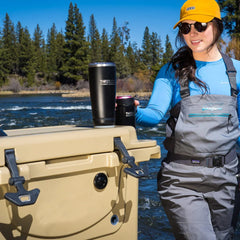 Fisher walking up to her cooler with an insulated tumbler attached to a cup holder on the lid.