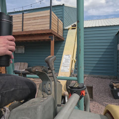 Double wall vacuum insulated coffee cup with a locking base on an excavator.