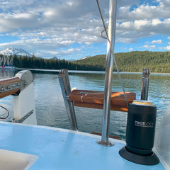 Sailboat cup holder attached near the transom with an insulated can cooler secured and locked into it.